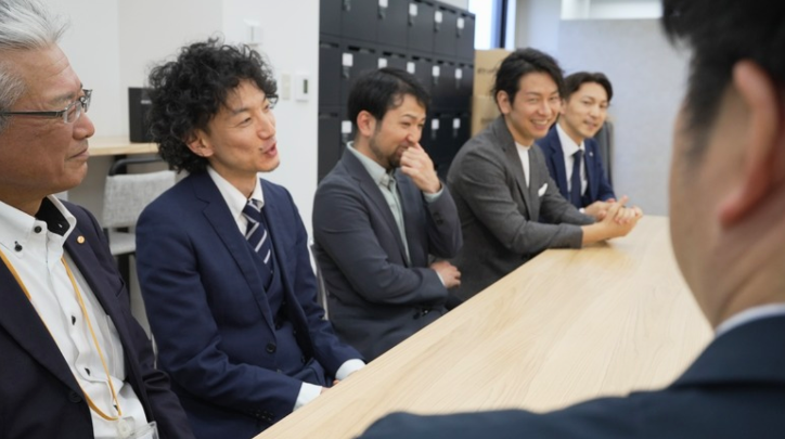林氏が、電気料金に関する住民からの声を語り、参加者が耳を傾ける様子。